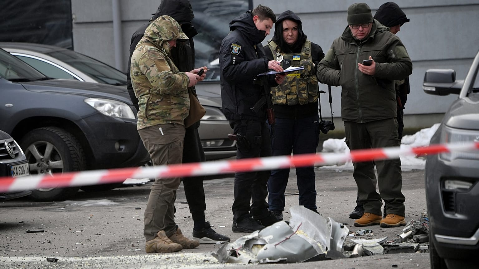 Police experts examine remains of a downed missile which fell on a vehicle parked at a multi storey residential building in Kyiv on December 29, 2022