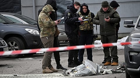 Police experts examine remains of a downed missile which fell on a vehicle parked at a multi storey residential building in Kyiv on December 29, 2022