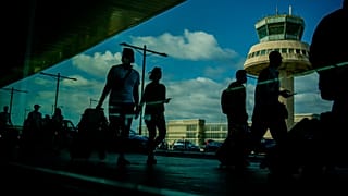Passengers carry luggage at the Barcelona airport, Spain, on July 9, 2021. 