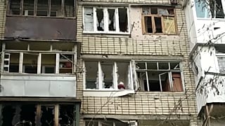 Un habitant à sa fenêtre détruite par un bombardement dans le quartier de Korabel, de la ville de Kherson, en Ukraine le 29 décembre 2022.