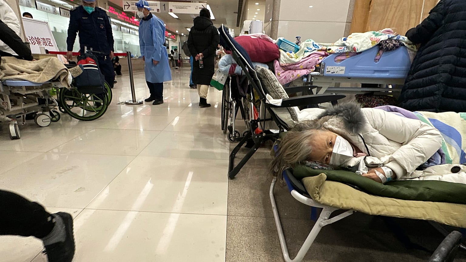 Elderly patients rest in an area cordoned off to provide intravenous drips at a hospital in Beijing, 31 December 2022