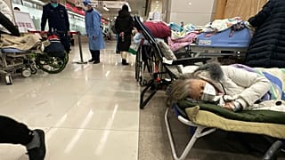 Elderly patients rest in an area cordoned off to provide intravenous drips at a hospital in Beijing, 31 December 2022