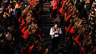 أشخاص يرتدون أزياء من فرو الدب يشاركون في عرض في كومانيستي، رومانيا، 30 ديسمبر 2022.