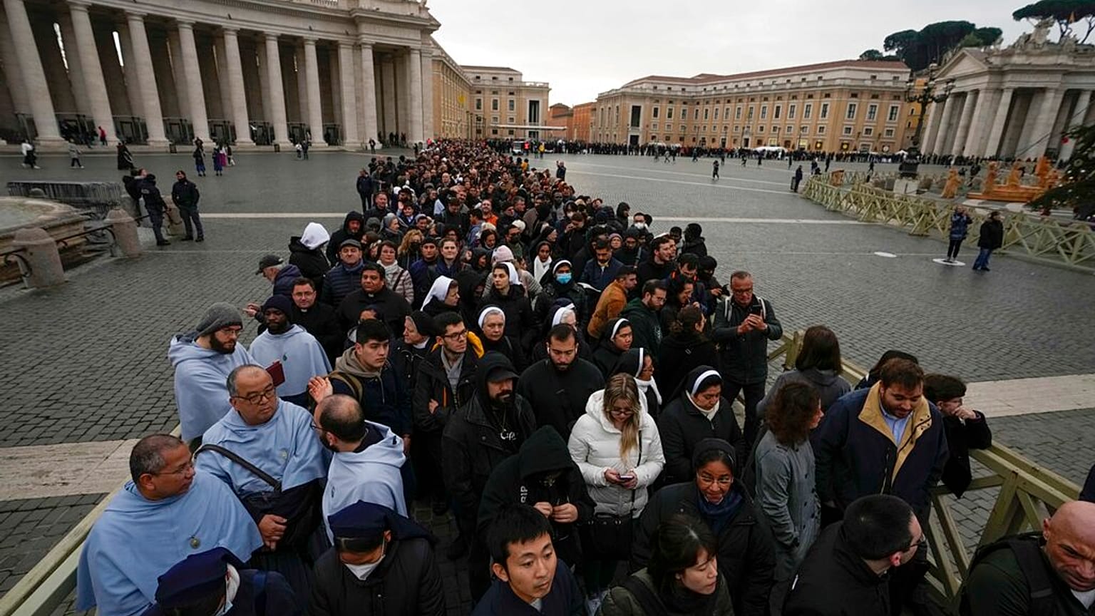 People wait in a line to enter Saint Peter's Basilica at the Vatican where late Pope Benedict 16 is being laid in state at The Vatican, Monday, Jan. 2, 2023.