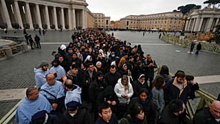 People wait in a line to enter Saint Peter's Basilica at the Vatican where late Pope Benedict 16 is being laid in state at The Vatican, Monday, Jan. 2, 2023.
