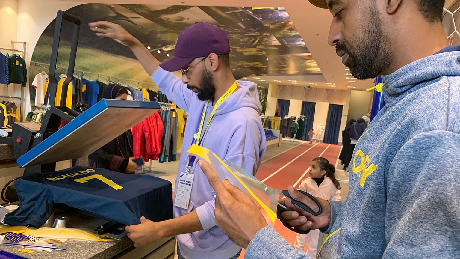 موظف يحضر قميصاً عليه اسم رونالدو في متجر نادي النصر بالرياض 