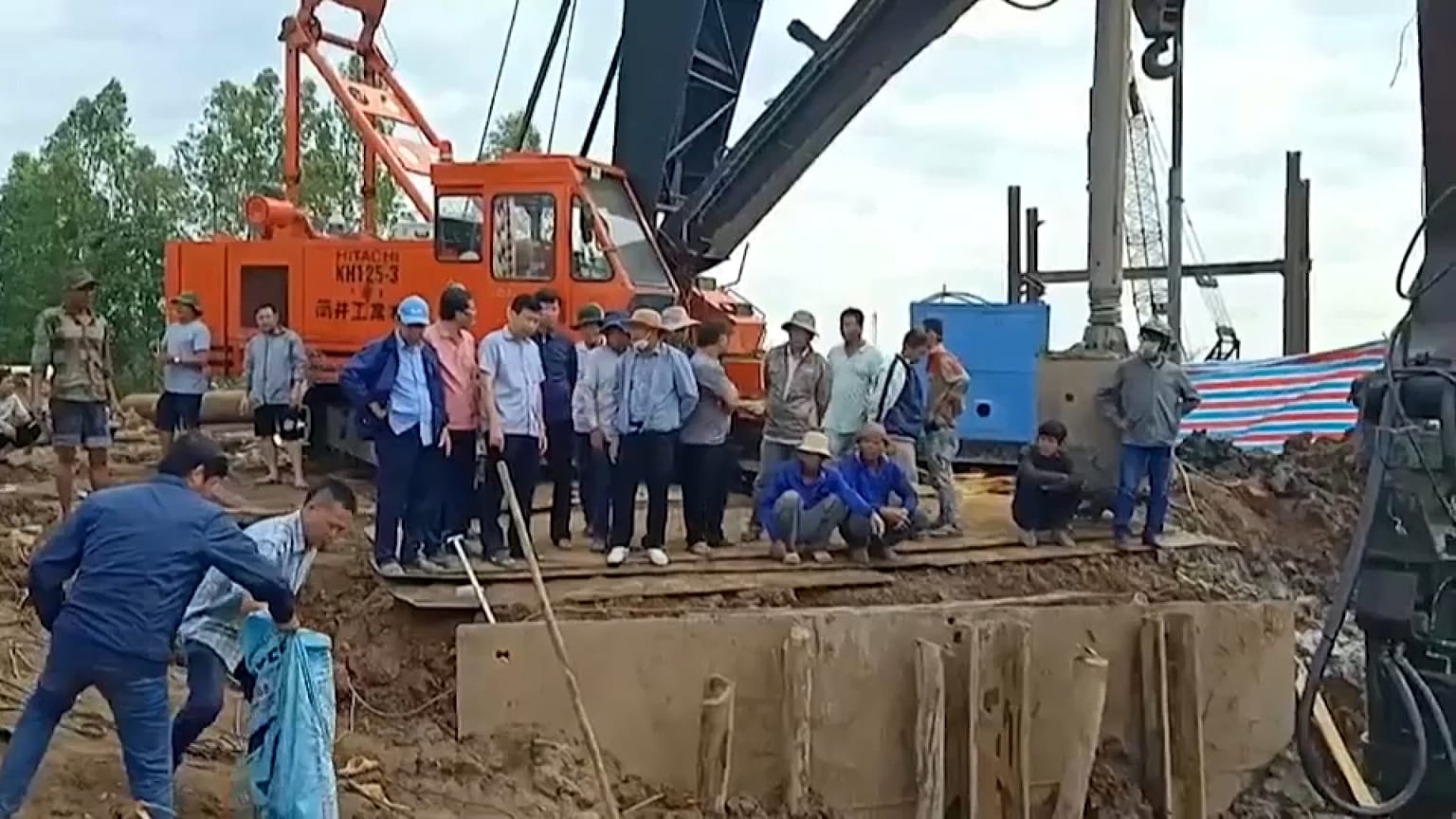 Rescatistas miran hacia el lugar donde se cree que está atrapado el niño de 10 años, Dong Thap, Vietnam, 2/1/2023