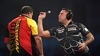 Gerwyn Price wears ear defenders as he plays against Germany's Gabriel Clemens