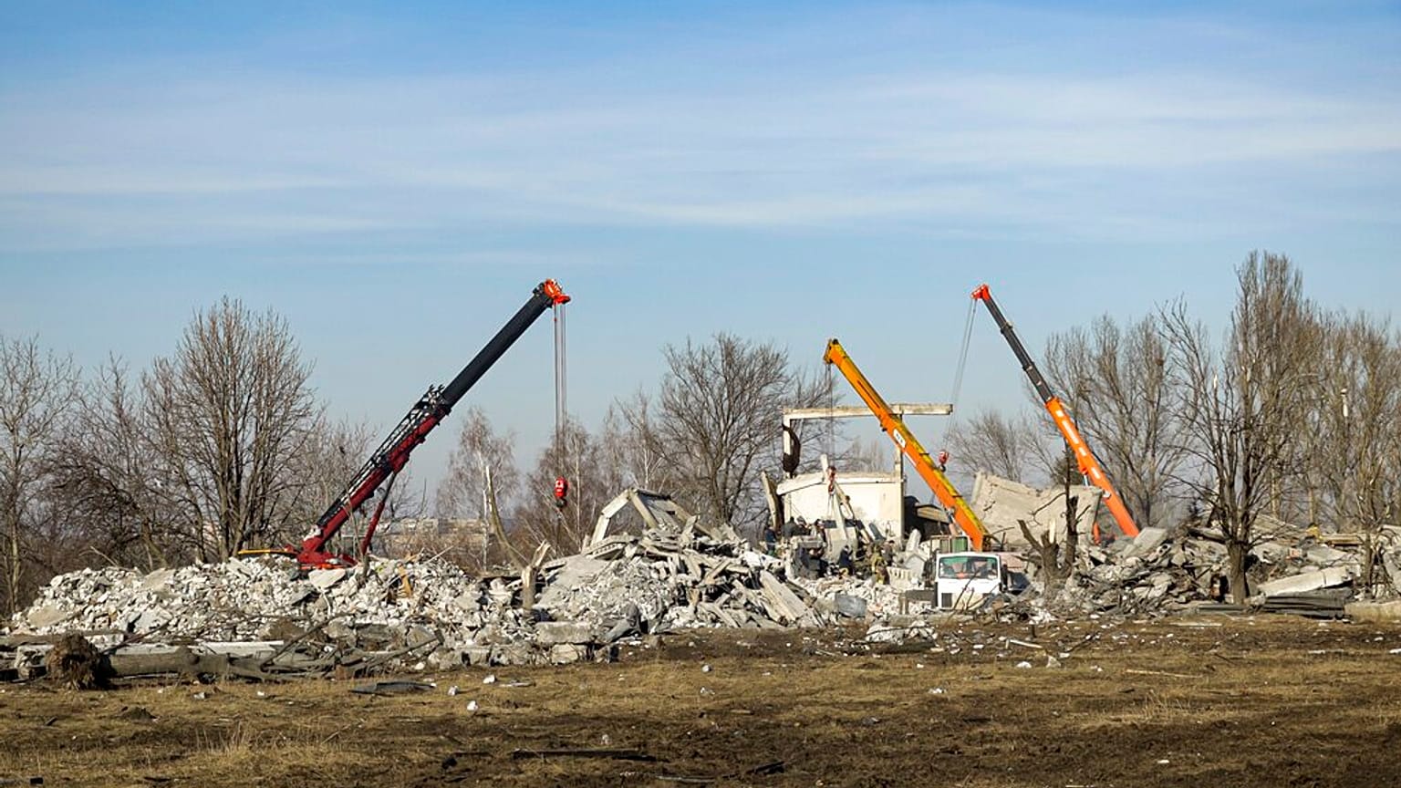 Workers clean rubbles after Ukrainian rocket strike in Makiivka, in Russian-controlled Donetsk region, eastern Ukraine, Tuesday, Jan. 3, 2023.