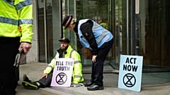 Un manifestant d'Extinction Rebellion avec sa main collée à l'exterieur de la Bourse de Londres. 25 avril 2019