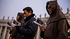 Des personnes prient pendant la messe des funérailles du Pape émérite Benoît XVI présidée par le Pape François sur la place Saint-Pierre au Vatican - 05.01.2023