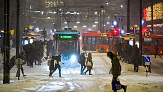 Straßenbahnen und Busse im Schneetreiben am Jernbanetorget im Zentrum von Oslo