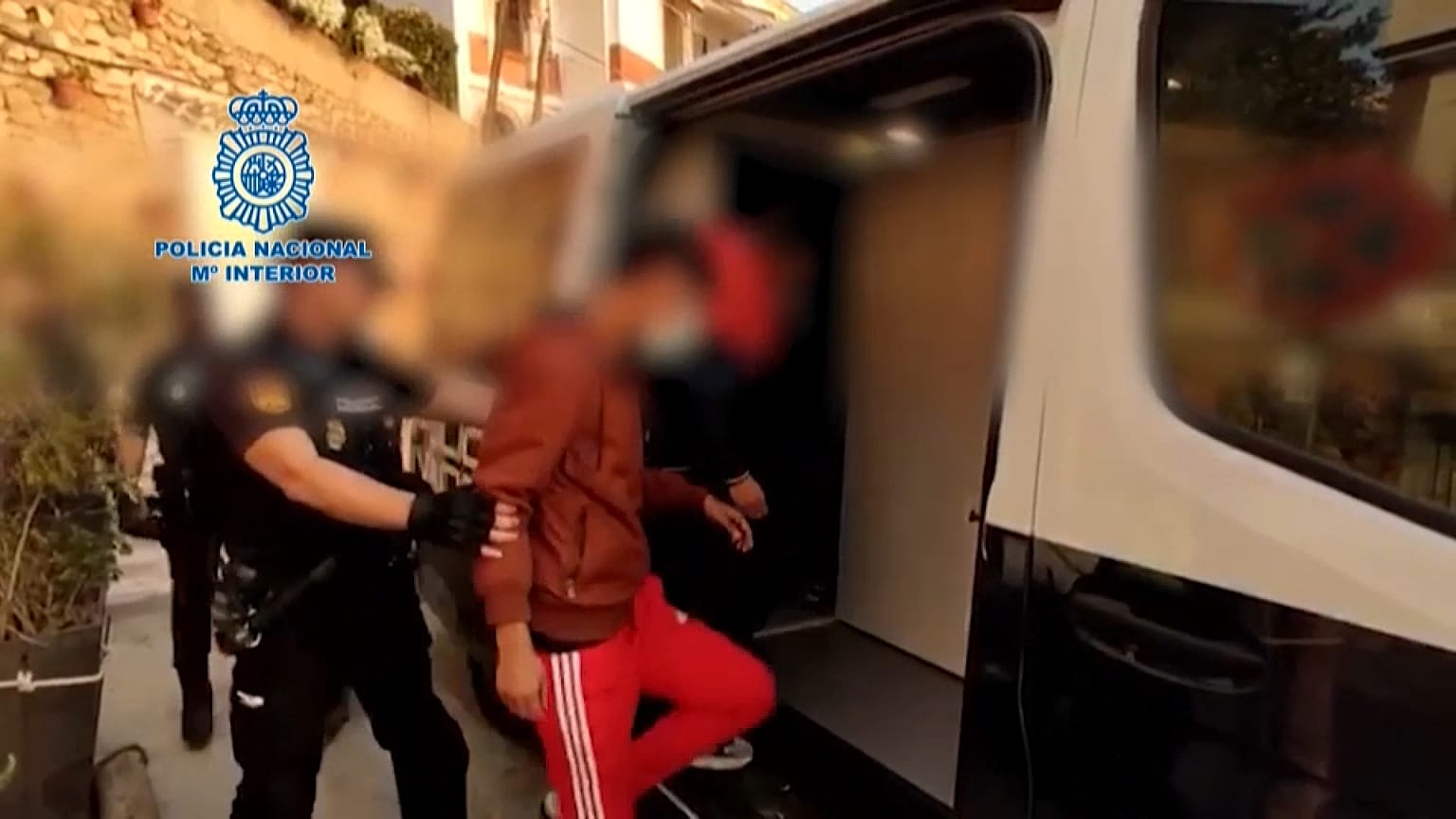 Policías introducen en el furgón policial a algunos de los detenidos en la operación