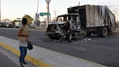 Une femme passe devant un camion incendié à Culiacan (Mexique).