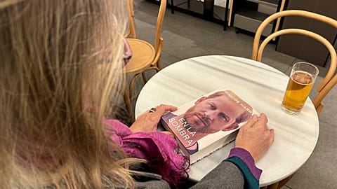 A woman holds a copy of "En La Sombra" (In the Shadow), the Spanish translation of Prince Harry's memoir "Spare" in Barcelona.