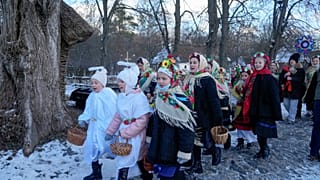 Ukrán népviseletbe öltözött gyerekek, karácsonyi énekeket énekelnek, ahogy meglátogatják szomszédaikat az ortodox karácsony alkalmából a Kijev mellett fekvő Pirogovo faluban