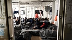 Migranti avvolti con coperte sulla nave di salvataggio Ocean Viking, nel mar Mediterraneo, vicino alla costa della Sicilia, 6 novembre 2022.