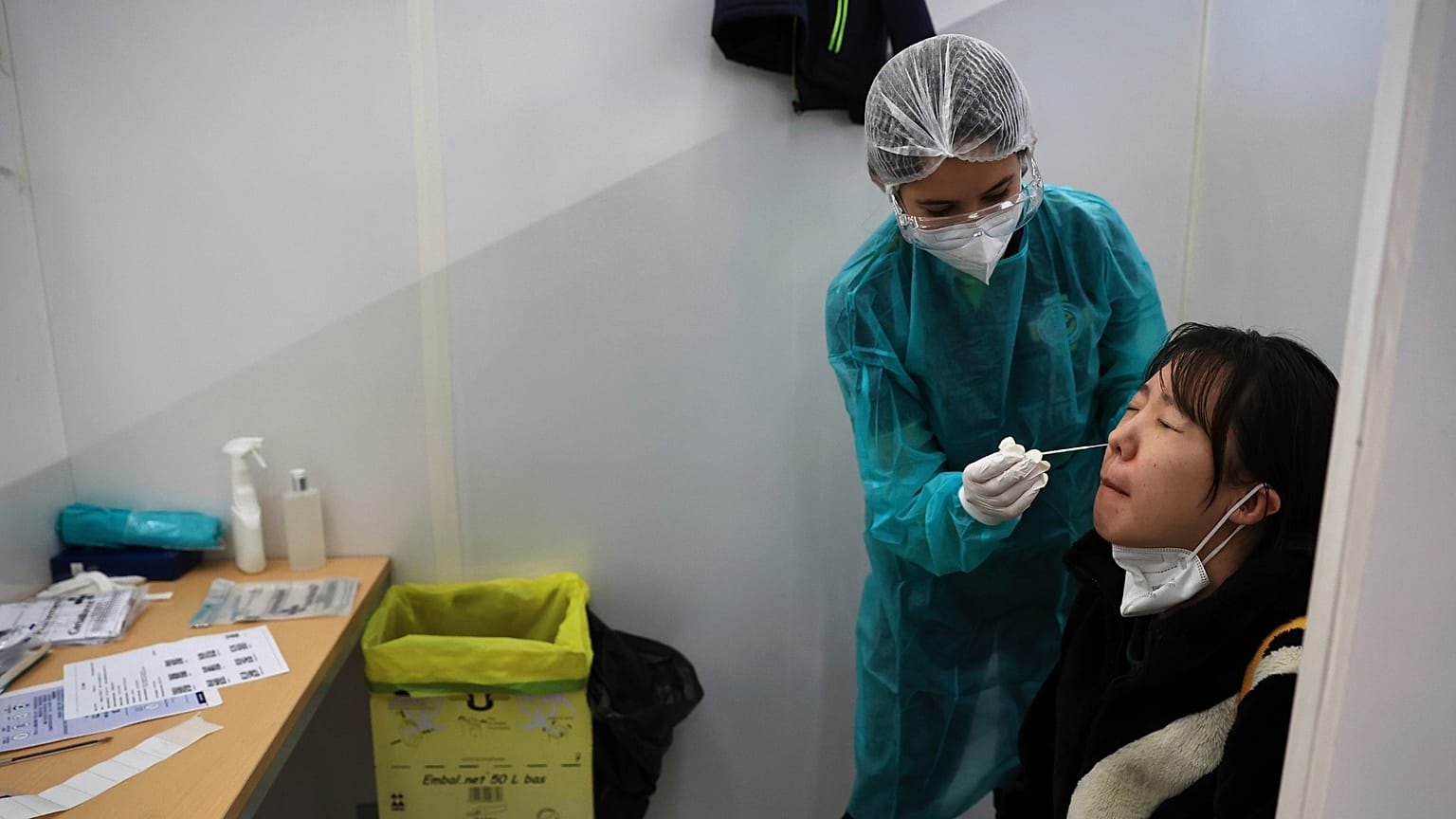 A passenger arriving from China is tested for COVID-19 at the Roissy Charles de Gaulle airport.