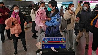 A man wearing a face mask meets with his child as he arrives from Hong Kong at Terminal 3 international arrival hall of the Beijing Capital International Airport in Beijing