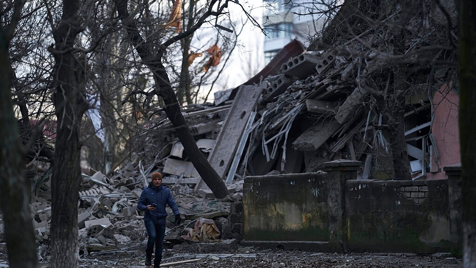Ukrayna'nın Donetsk bölgesindeki Kramatorsk kentinde Rus saldırısı sırasında ağır hasar gören bir okul binasının önünden geçen vatandaş