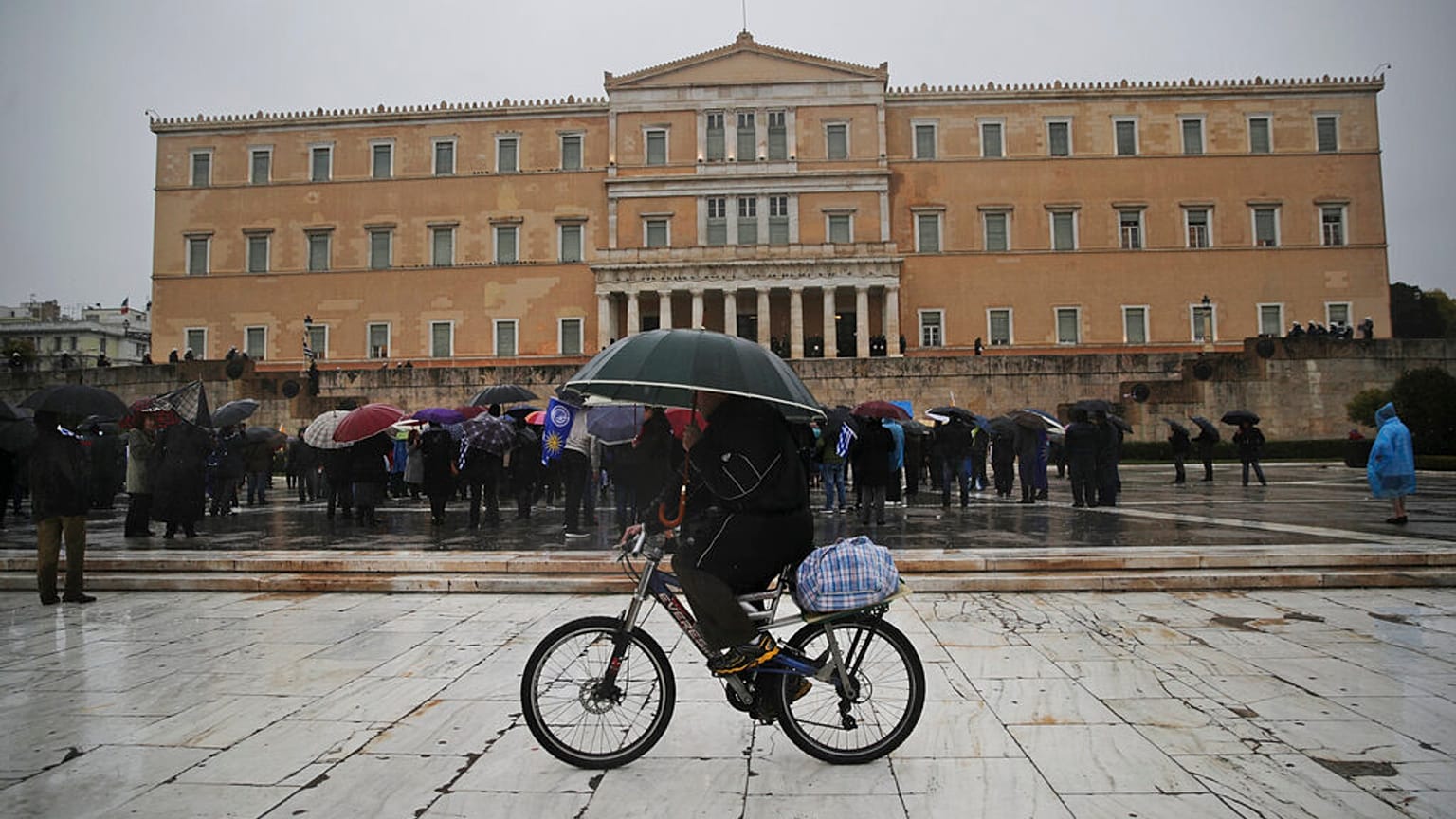Ποδηλάτης με ομπρέλα στο κέντρο της Αθήνας