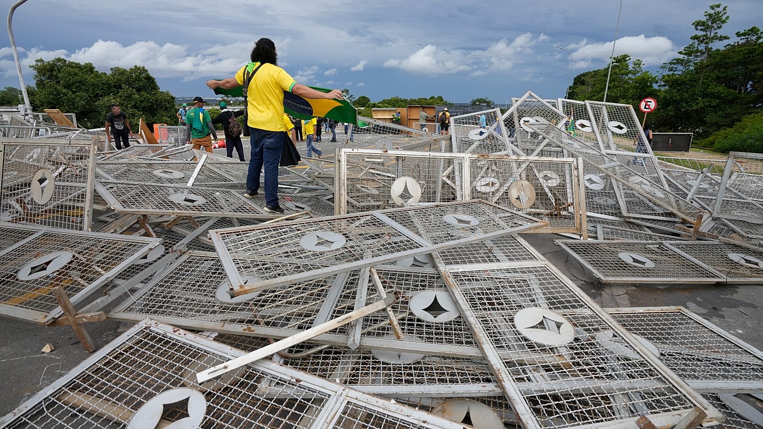 Protesters, supporters of Brazil's former President Jair Bolsonaro, stand over barricades as they storm the Planalto Palace in Brasilia, Brazil.