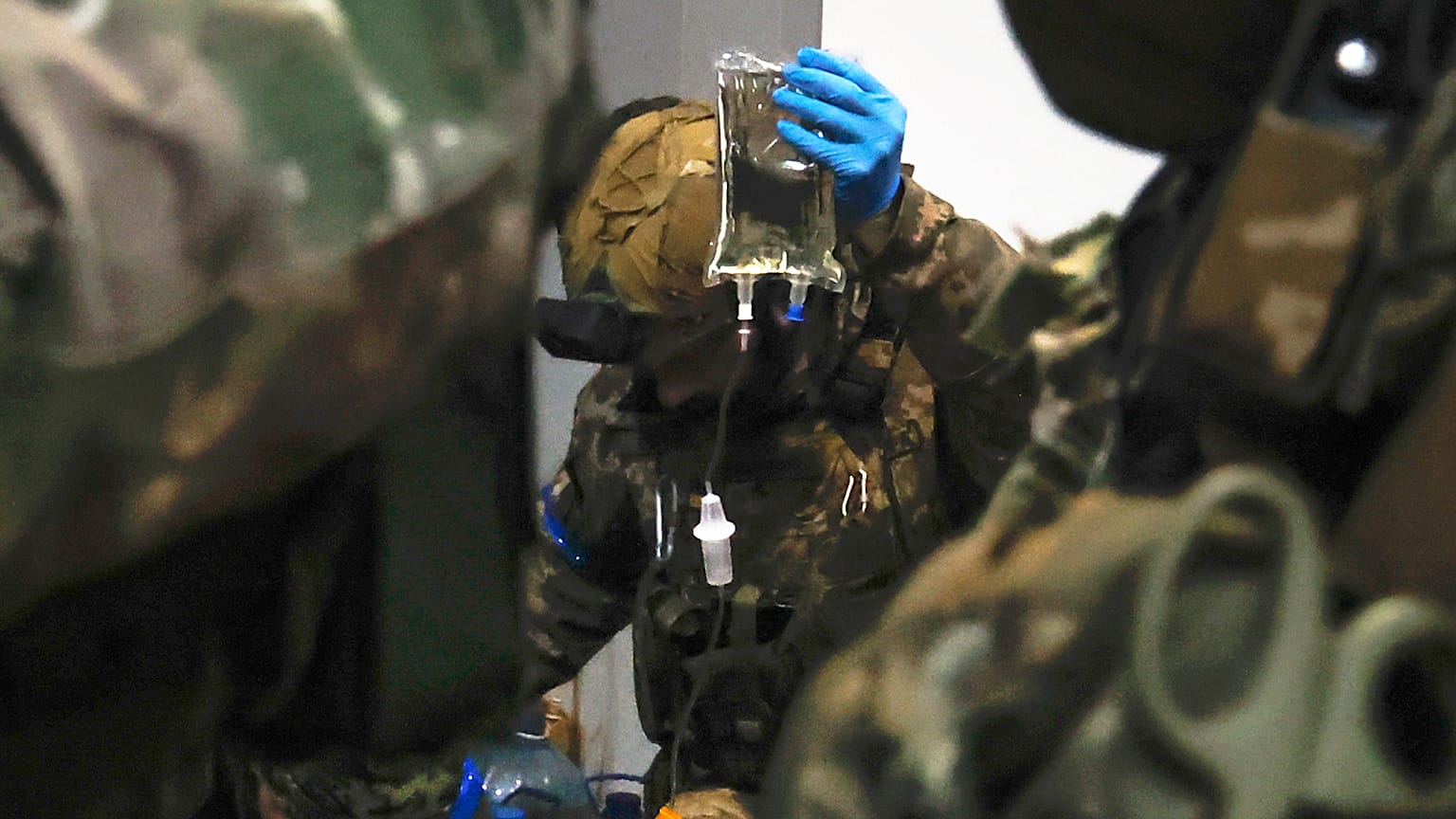 Ukrainian servicemen administer first aid to a wounded soldier in a shelter in Soledar, the site of heavy battles with Russian forces in the Donetsk region, 8 January 2022