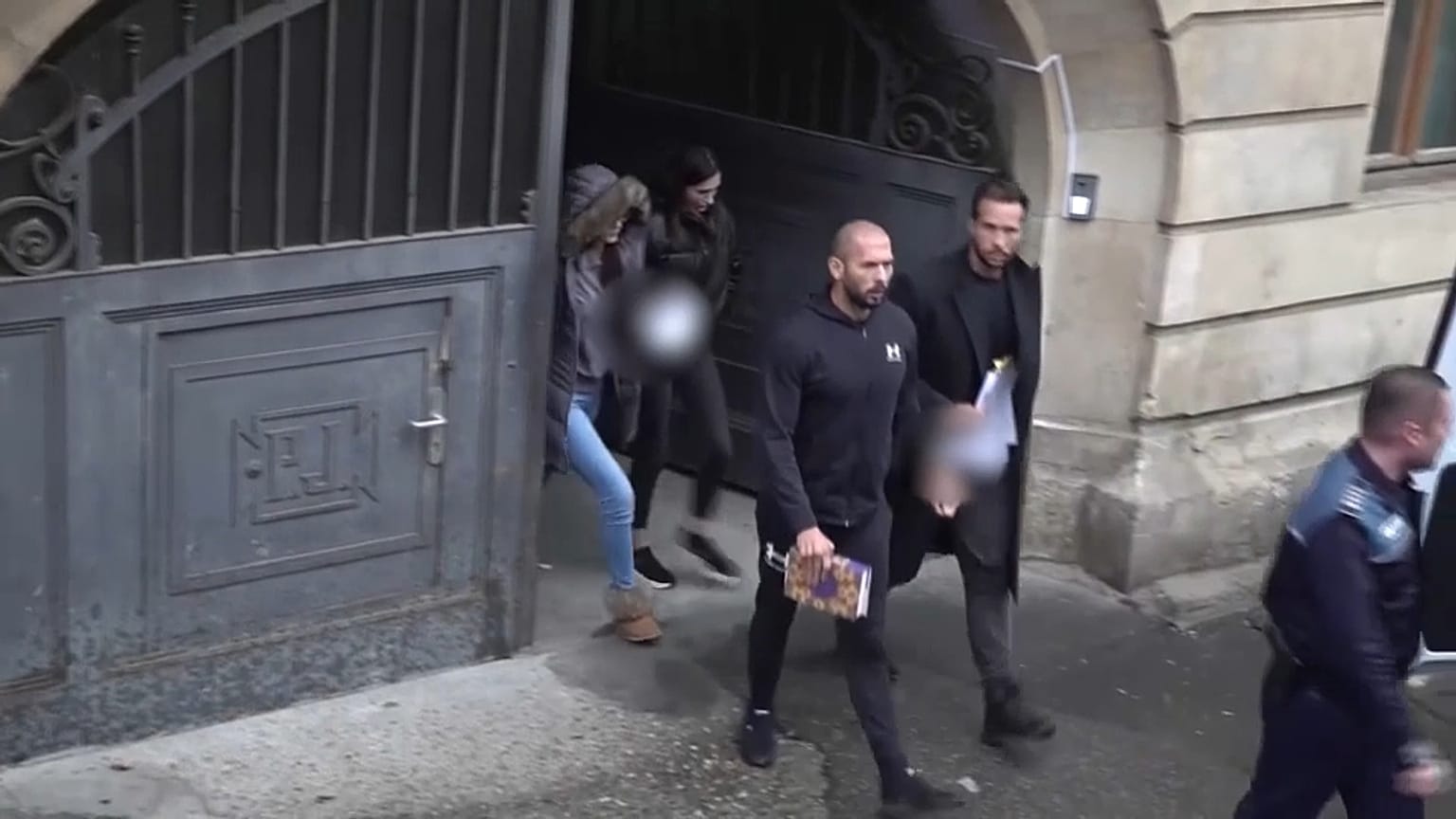 Tate brothers leave Romanian court in handcuffs