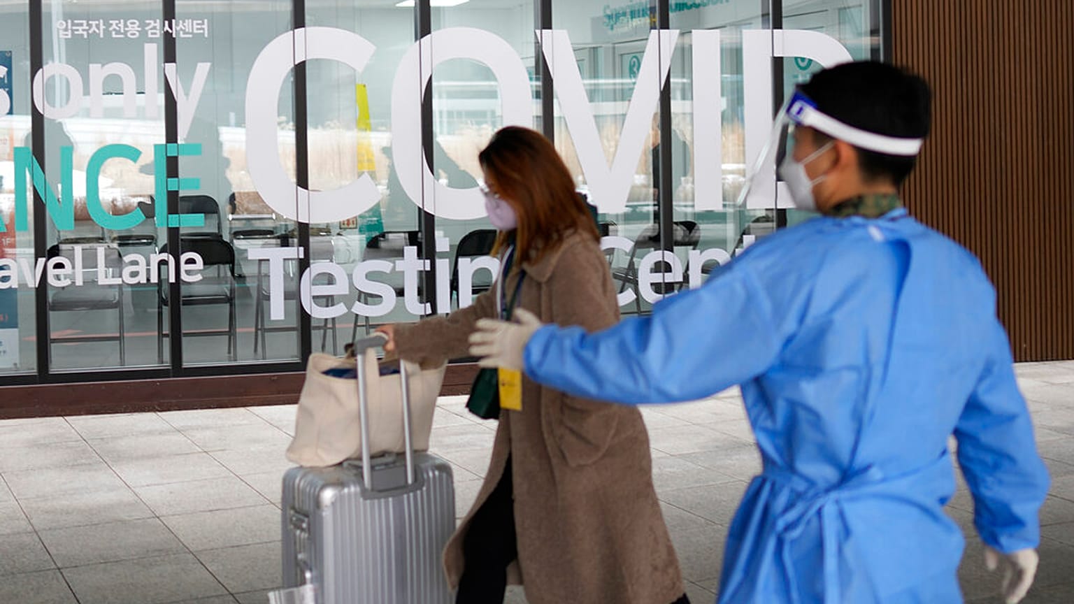 Çin'den gelen bir kadın Güney Kore'deki Incheon Uluslararası Havalimanı'nda Covid-19 test merkezine giriyor