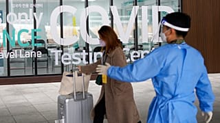 Çin'den gelen bir kadın Güney Kore'deki Incheon Uluslararası Havalimanı'nda Covid-19 test merkezine giriyor
