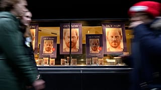 Pedestrians pass a display in the window of a book shop in London on Tuesday. 