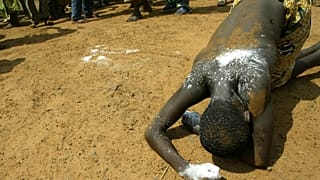 A woman collapses in a trance after being possesed by the voodoo spirits in Ouidah, Benin.