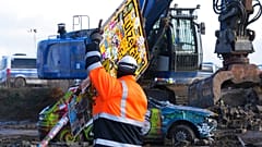 Ein Arbeiter des Energiekonzerns RWE demontiert das Ortsschild des Dorfes Lützerath