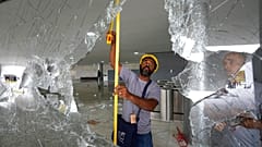 Des ouvriers mesurent les fenêtres brisées du palais de Planalto au lendemain de l'assaut des partisans de Jair Bolsonaro à Brasilia, lundi 9 janvier 2023. 