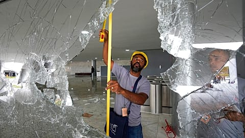 Des ouvriers mesurent les fenêtres brisées du palais de Planalto au lendemain de l'assaut des partisans de Jair Bolsonaro à Brasilia, lundi 9 janvier 2023. 