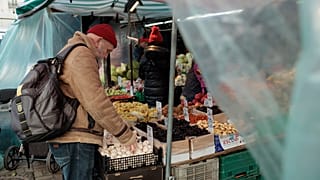 Un hombre compra en un puesto de verduras al aire libre en el mercado Hala Mirowska de Varsovia.