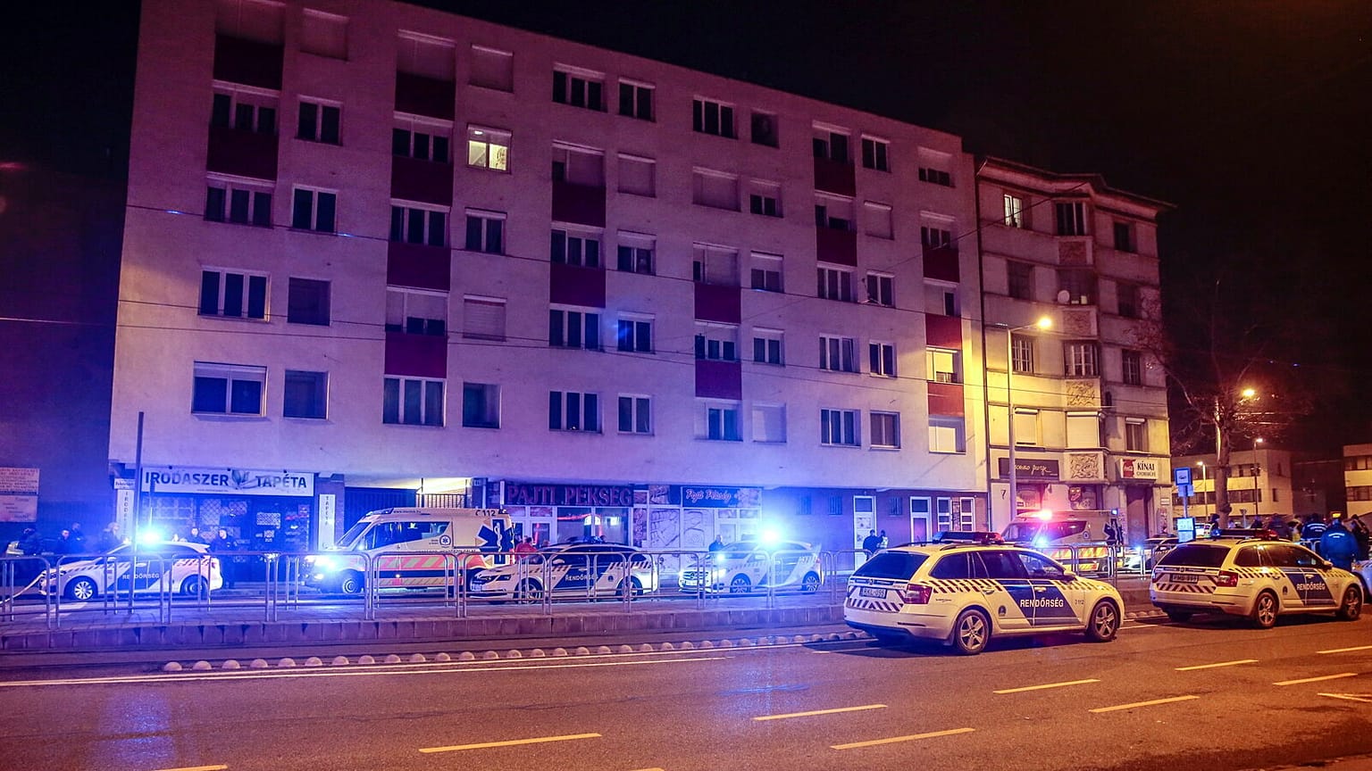 Patrol vehicles block a road at a residential building in Budapest, Hungary, late Thursday, 12 Jan. 2023.