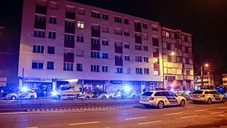 Patrol vehicles block a road at a residential building in Budapest, Hungary, late Thursday, 12 Jan. 2023.