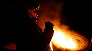 An Indigenous person stands by a burning tire at a roadblock to protest Peruvian President Dina Boluarte's government and Congress in Cuzco, Peru, January 12, 2023