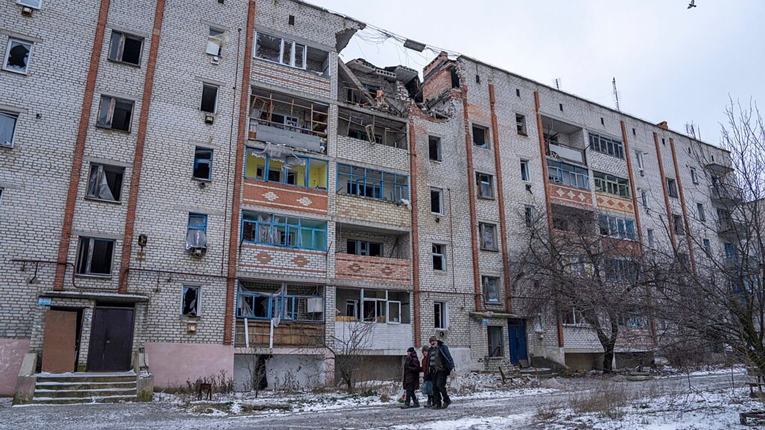 Residentes locales caminan frente a una casa destruida por los bombardeos rusos en Siversk, región de Donetsk, Ucrania.