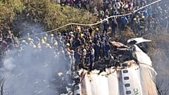Nepalese rescue workers and civilians gather around the wreckage of a passenger plane that crashed in Pokhara, Nepal, Sunday, Jan. 15, 2023. . 