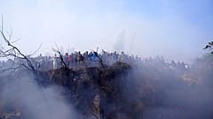 Locals watch the wreckage of a passenger plane in Pokhara, Nepal, Sunday, Jan.15, 2023. 