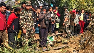 Vecinos observan los restos de un avión de pasajeros en Pokhara, Nepal, el domingo 15 de enero de 2023