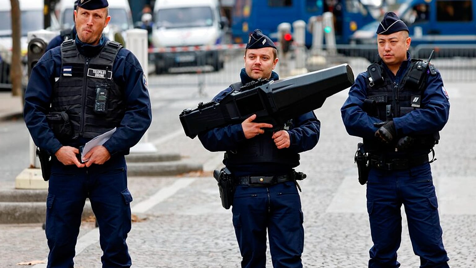 French police officers stand guard with an anti-drone gun, centre, during ceremonies Friday Nov.11, 2022.