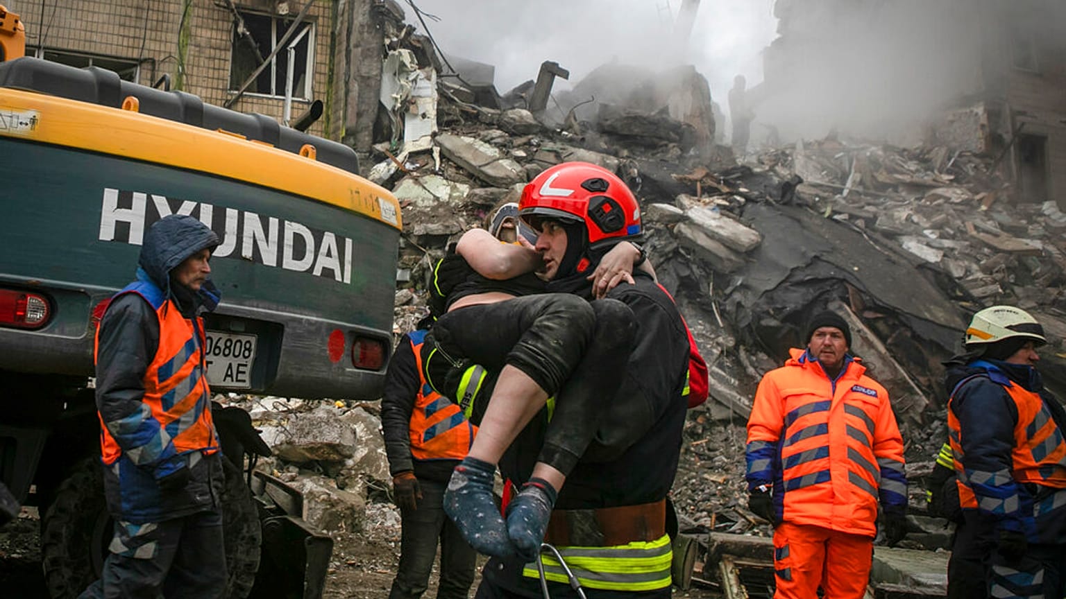 Emergency workers carry a wounded woman after a Russian rocket hit a multistory building on Saturday in Dnipro, Ukraine, Sunday, Jan. 15, 2023. 