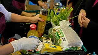 Volunteers pack boxes with food for customers at the community food pantry in Vauxhall, London, Wednesday, Nov. 16, 2022. 