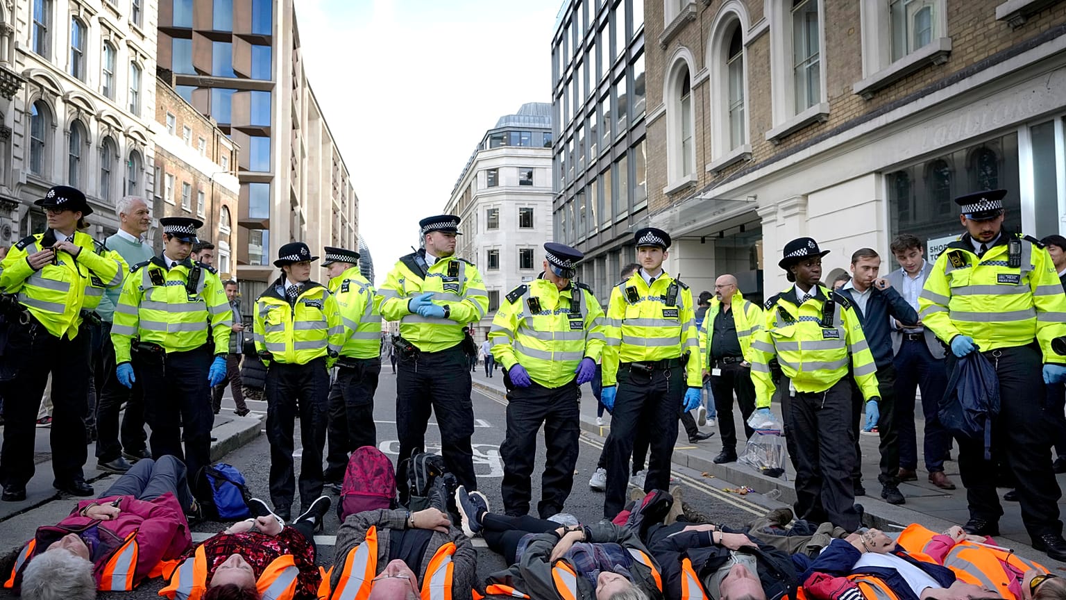 Handcuffed activisits from the group Just Stop Oil lie on the road as they are arrested after they blocked a road in London. Thursday, 27 October 2022