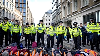 Handcuffed activisits from the group Just Stop Oil lie on the road as they are arrested after they blocked a road in London. Thursday, 27 October 2022