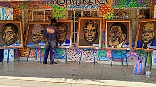 Patrick Cikuru Cirimwami with a collection of his portraits of D.R.C. politicians.
