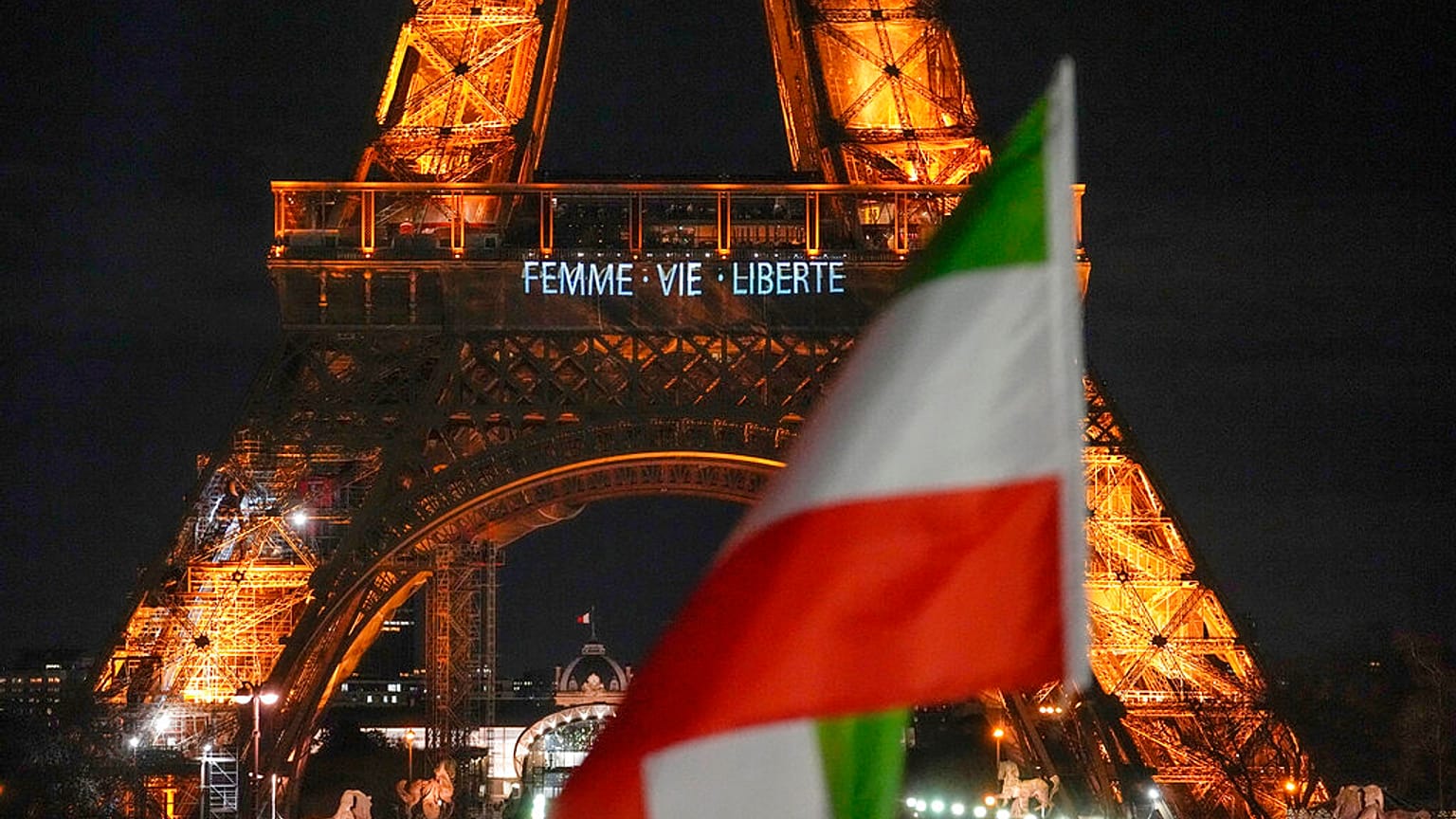 La Torre Eiffel ilumina la noche con los lemas "Mujer, vida, libertad" y "Alto a las ejecuciones en Irán" en apoyo a las protestas en Irán en París, lunes 16 de enero de 2023.